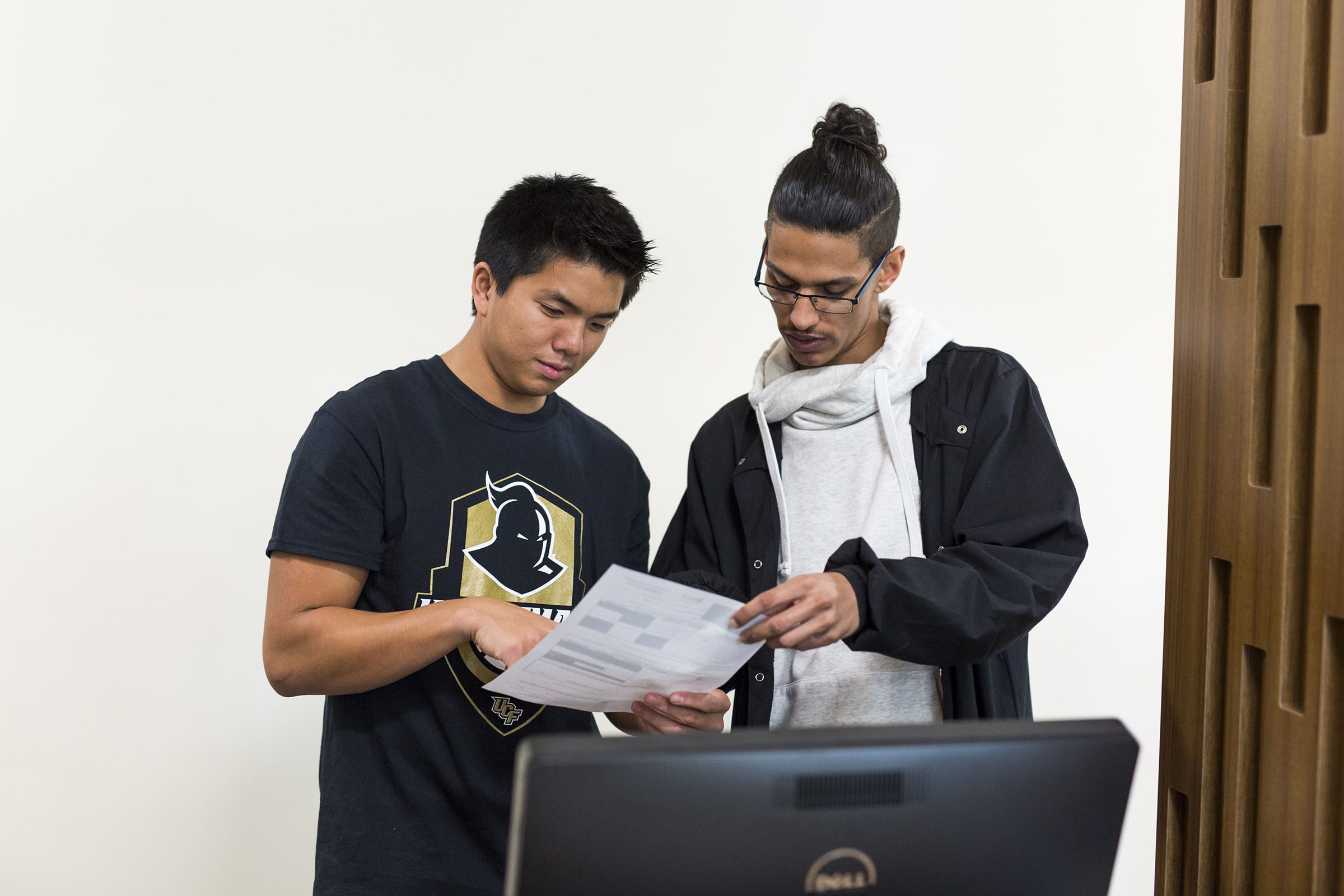 Two UCF students reviewing documents, University of Central Florida — estudiantes de UCF revisando documentos académicos